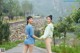 A couple of women standing next to each other on a road.