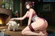 A woman kneeling on the floor next to a white rabbit.