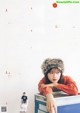 A woman in a fur hat sitting on top of a box.