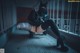 A woman in a black outfit crouching down on the ground.