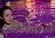 A woman in a swimming pool holding a string.