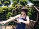 A woman holding a spray gun on a wooden deck.