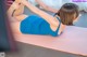 A woman in a blue dress is doing a yoga pose.