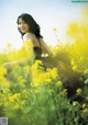 A woman in a field of yellow flowers.