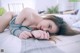 A woman laying on a bed with her hands on her face.